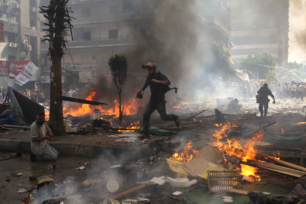 يفر الصحفيون خلال الاشتباكات بين جماعة الإخوان المسلمون من أنصار الرئيس المصري المخلوع محمد مرسي وقوات الشرطة يوم 14 أغسطس .2013 أثناء عملية إخلاء مخيم رابعة العدوية
AFP/ Stringer