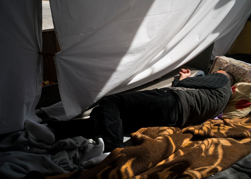 Masih is visibly exhausted, stressed and deeply frustrated at his situation. “Everybody is sleeping on the floor in the old terminal hall. I don’t sleep in there – it’s smelly.” Instead he has created this makeshift shelter outside. © Amnesty International/Olga Stefatou