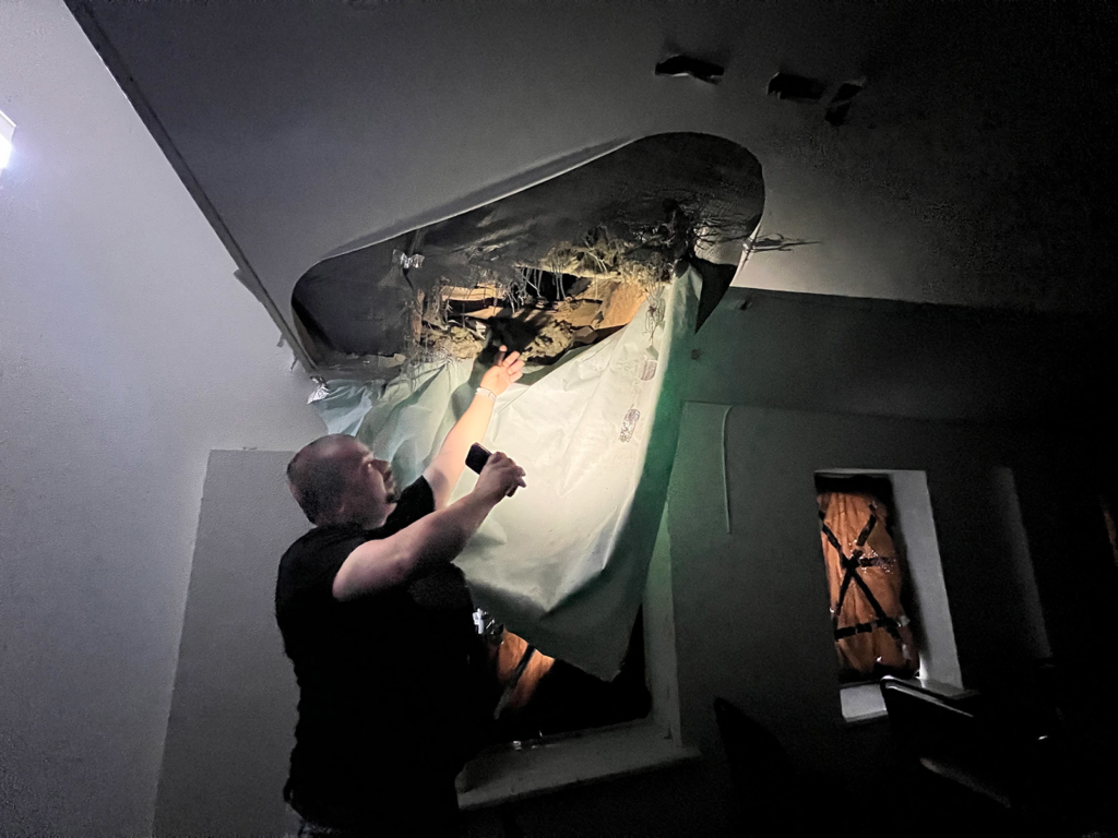 Pastor Petro Loboiko showing damage to the church’s ceiling from the cluster munitions explosion on 24 March.