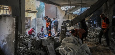 Palestinian residents in Gaza inspect the destruction caused by air strikes on their homes on December 01, 2023 in Khan Yunis, Gaza. In the image, rescue workers wearing red uniform as well as people in civilian clothing are seen standing amonst the rubble inside a destroyed building. Photo credit: Ahmad Hasaballah/Getty Images) on 1 December, 2023.