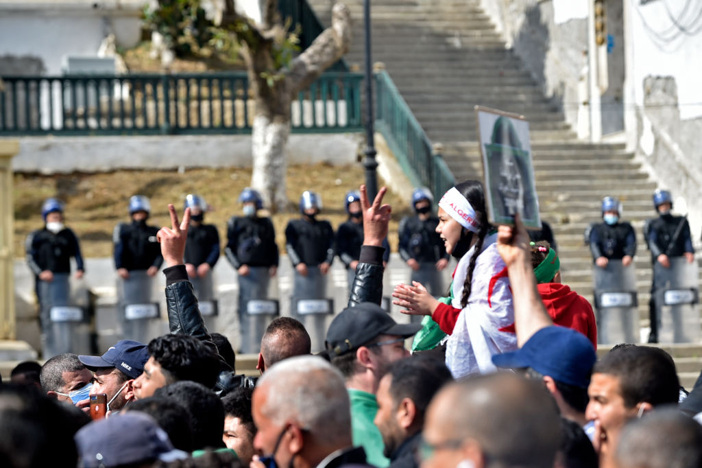 Algerian security forces stand guard as demonstrators march during an anti-government protest in the capital Algiers on March 5, 2021. - Thousands of people demonstrated in Algiers and other cities across the country, confirming the remobilization of the Hirak protest movement again in the streets since the second anniversary of the uprising on February 22. (Photo by RYAD KRAMDI / AFP) (Photo by RYAD KRAMDI/AFP via Getty Images)