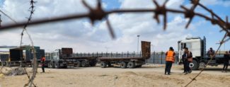 Trucks wait at the Rafah border gate to cross to the Egyptian side