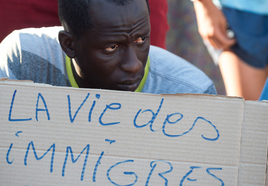 A protester is holding a placard expressing his opinion during a demonstration in solidarity with migrants. Hundreds of pro-human rights activists protested against deaths in Melilla after dozens of migrants died at the Spanish-Moroccan border
