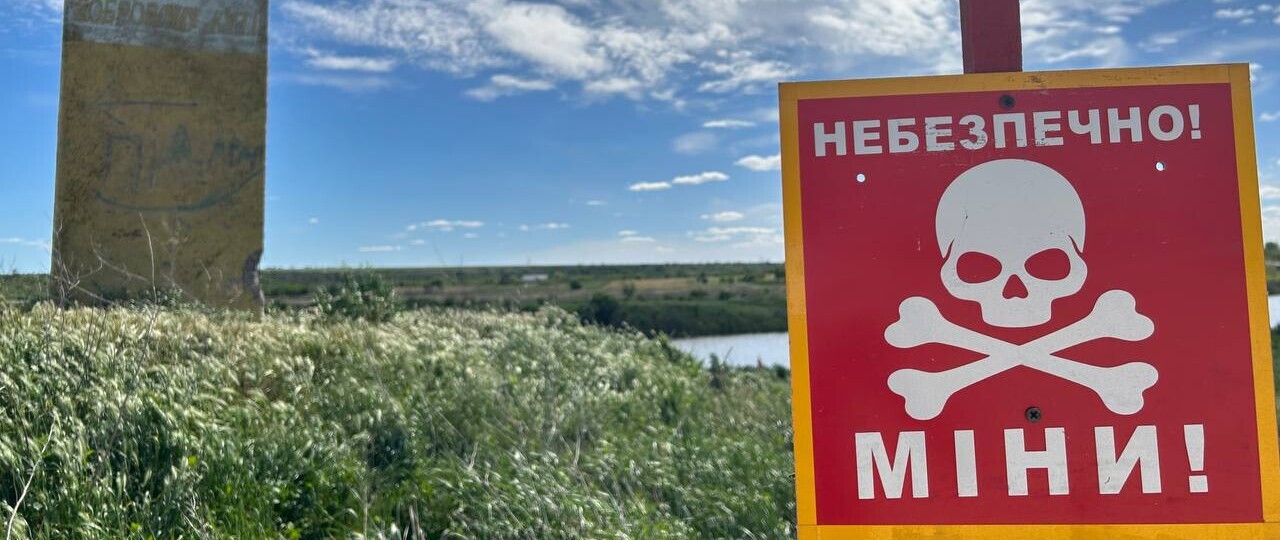 Mine sign by a river in in Kalynivka, Kharkiv oblast.