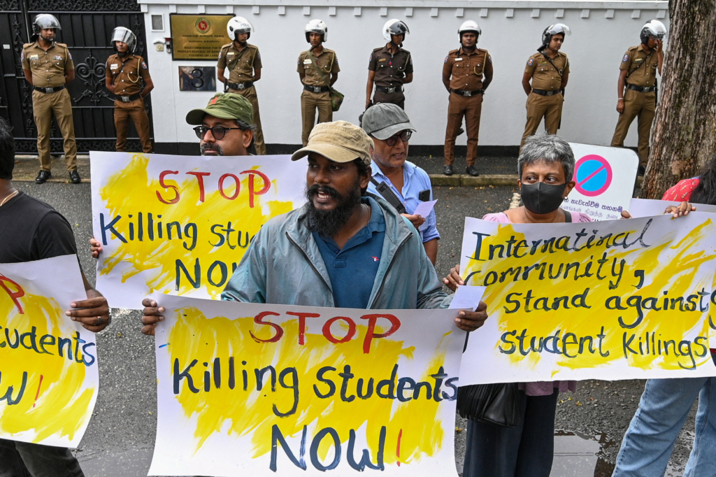 people at a protest holding signs that say 'stop killing students now' and 'international community, stand against student killings'