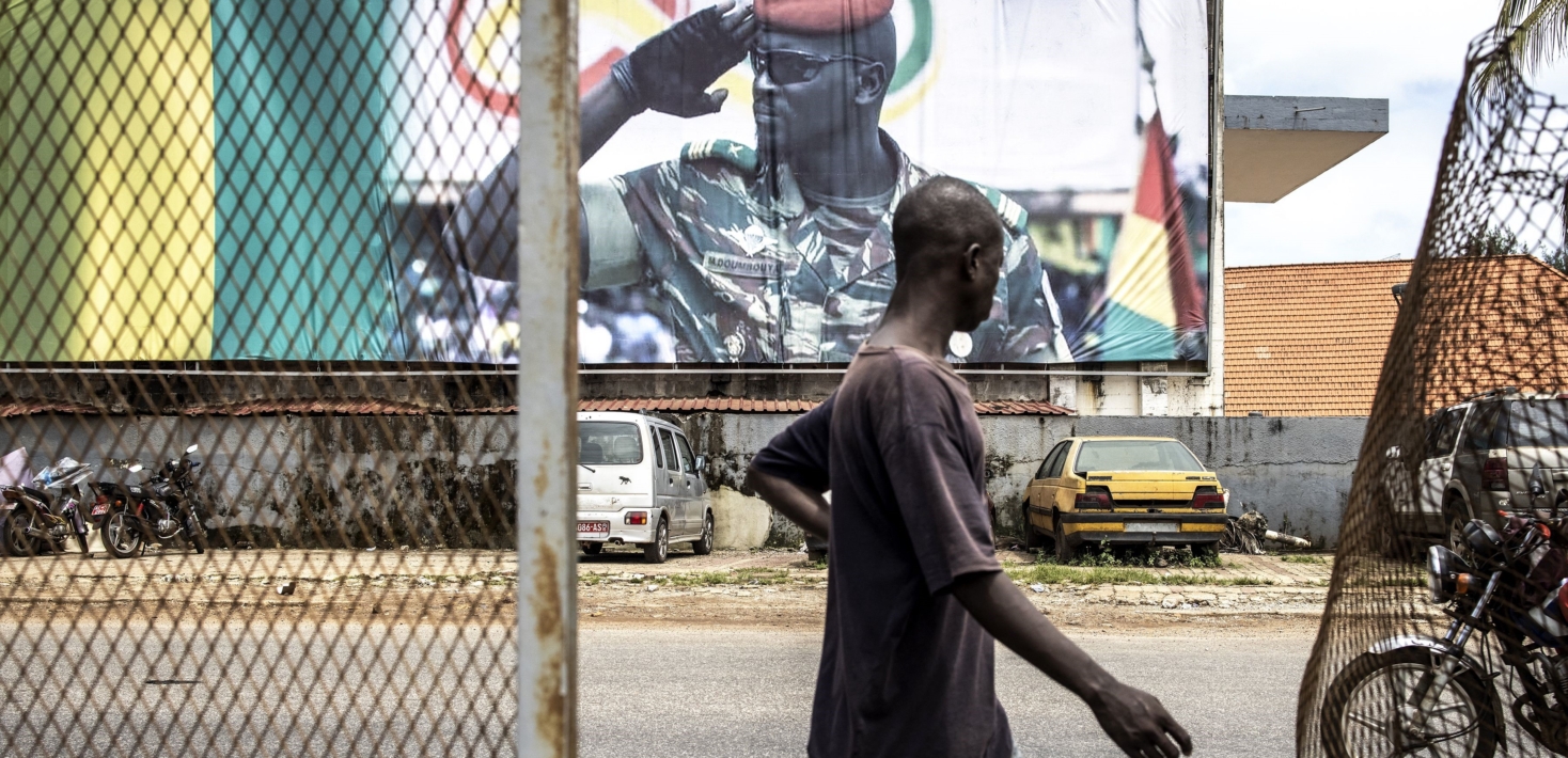 A man walks past a billboard showing junta leader, Colonel Mamady Doumbouya, in Conakry in 2021.