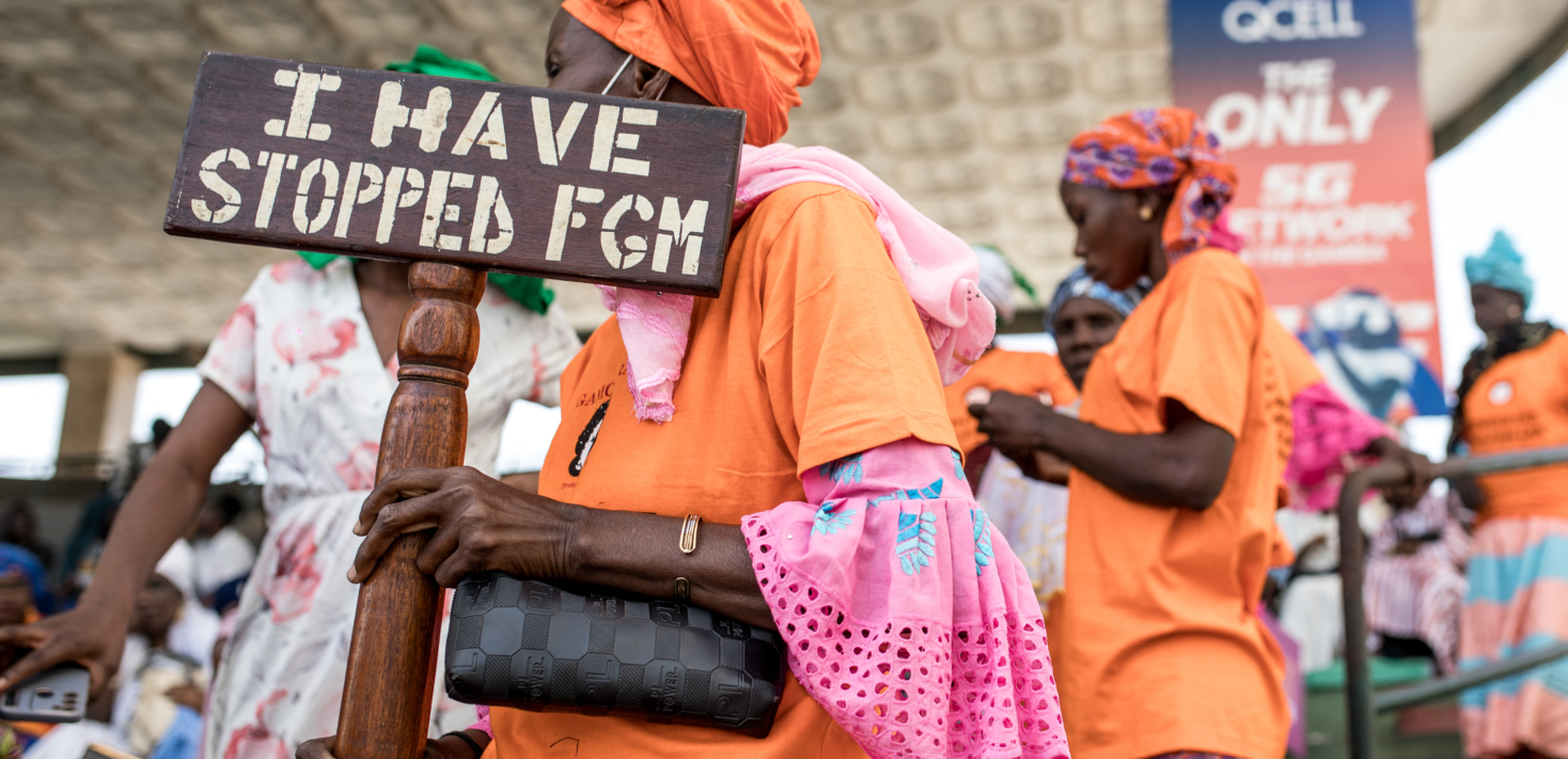 A anti Female Genital Mutilation protester holds a placard outside the National Assembly in Banjul on march 18, 2024, during the debate between lawmakers on a highly controversial bill seeking to lift the ban on FGM.