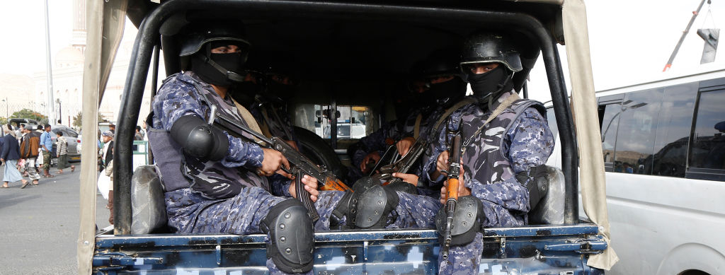 Security troops ride a police vehicle