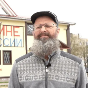 Dmitry Skurikhin stands in front of his shop, painted with anti-war messages.