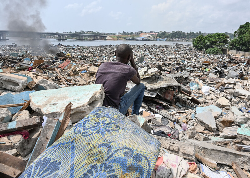 Resident sits on rubbles of demolished houses in Boribana, in Abidjan on 25 February 2024.