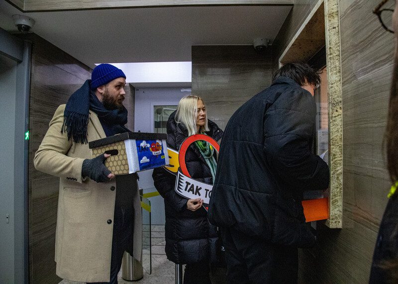 Tres personas que han participado en la campaña hacen entrega de una caja que contiene los llamamientos.