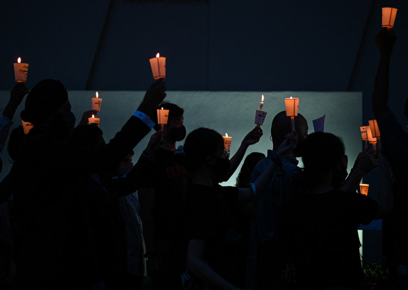 Un grupo de personas con velas en una vigilia.