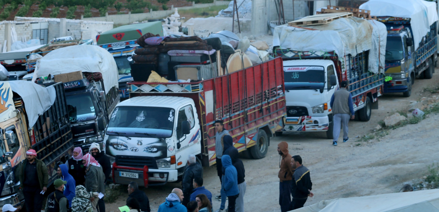 Refugiados sirios de pie junto a camiones que transportan sus pertenencias mientras se preparan para salir de Líbano y regresar a Siria, en Arsal, valle de Bekaa, el 14 de mayo de 2024.