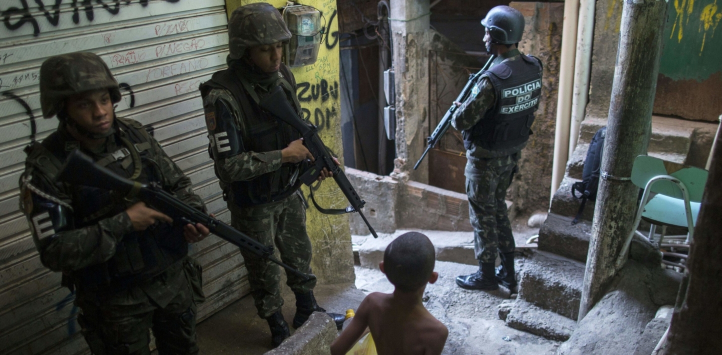 Heavily armed Brazilian army military police personnel patrol along an alley in the Rocinha favela in Rio de Janeiro